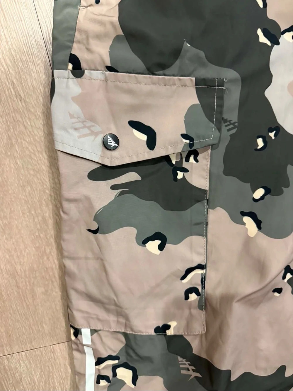 Paper Planes multi-pocket cargo pants featuring an all-over camouflage print